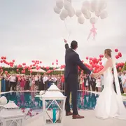 Los novios con globos junto a la piscina